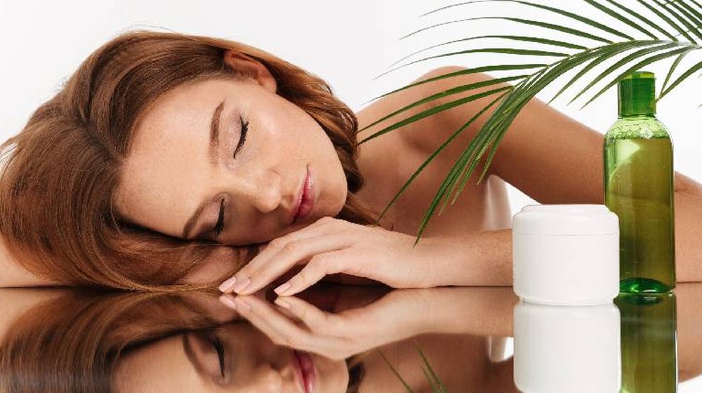 Woman resting peacefully with skincare beside her
